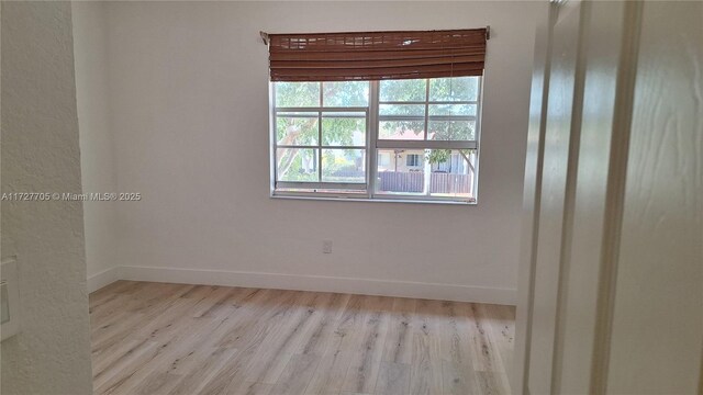 spare room featuring light hardwood / wood-style floors and a healthy amount of sunlight