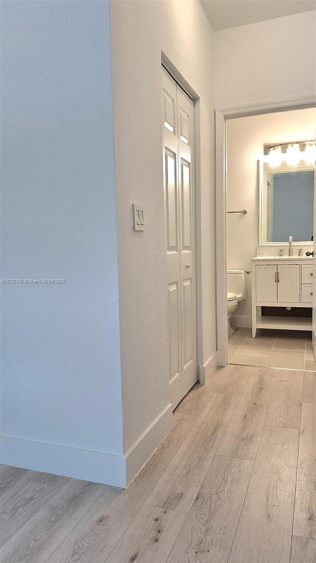 hall featuring sink and light hardwood / wood-style floors