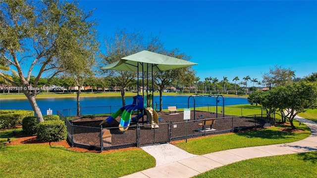 view of playground featuring a lawn and a water view