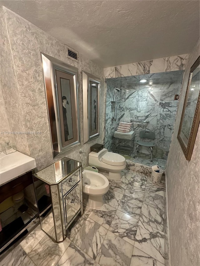 bathroom with a bidet, toilet, and a textured ceiling