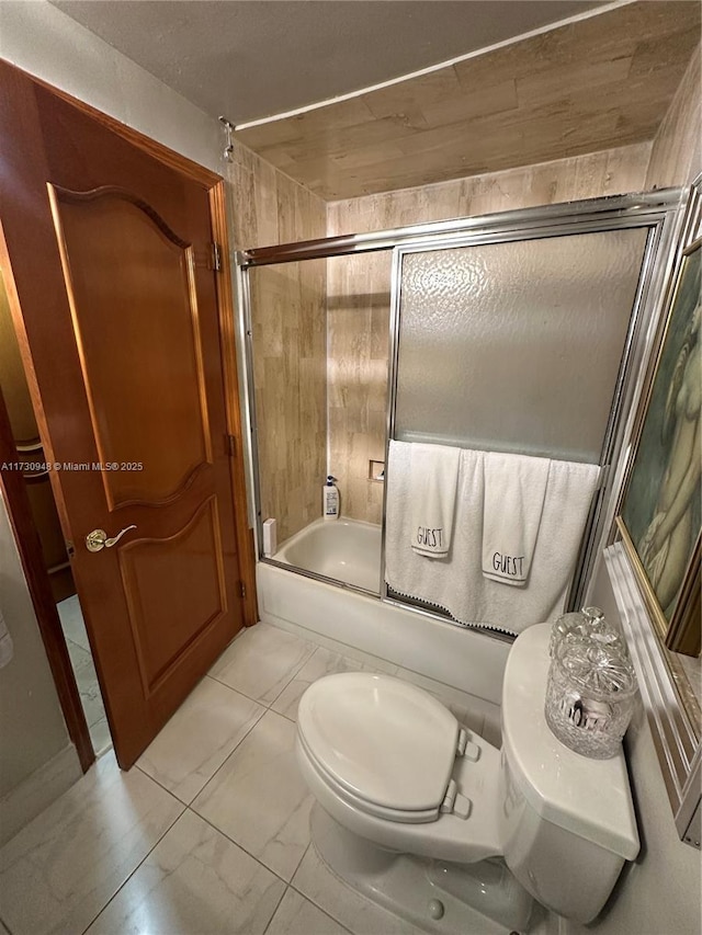 bathroom with toilet and combined bath / shower with glass door