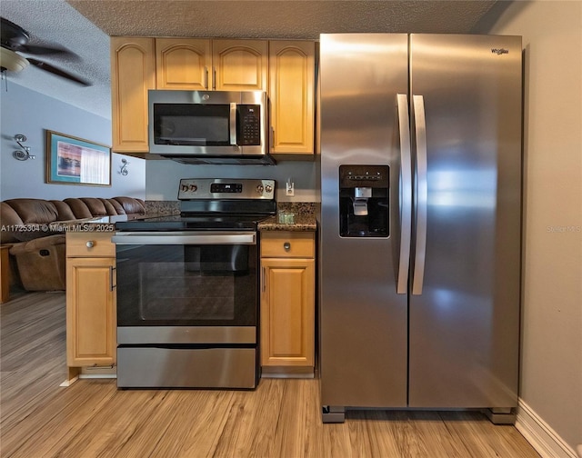 kitchen with ceiling fan, appliances with stainless steel finishes, light hardwood / wood-style floors, and a textured ceiling