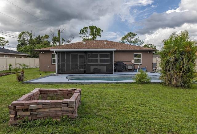 rear view of property with a fenced in pool, a patio, a sunroom, and a lawn