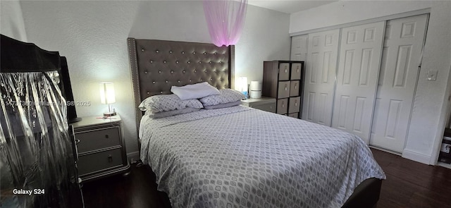 bedroom with dark hardwood / wood-style flooring and a closet