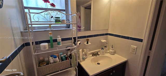 bathroom with vanity and tile walls