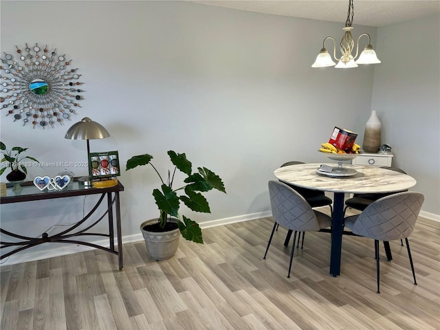 dining room featuring a notable chandelier and light hardwood / wood-style flooring