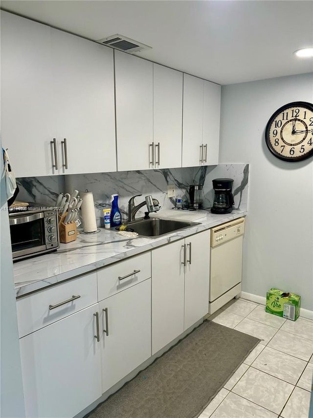 kitchen with white dishwasher, sink, decorative backsplash, and white cabinets