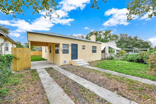 bungalow-style house with a front lawn and a carport