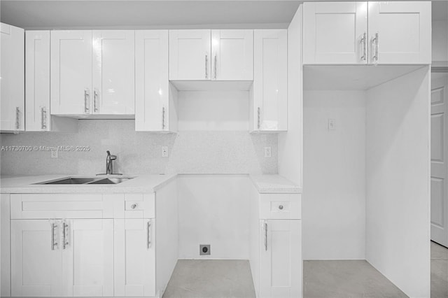 kitchen with backsplash, sink, and white cabinets