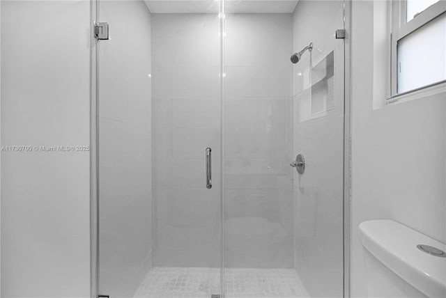 bathroom with an enclosed shower and toilet