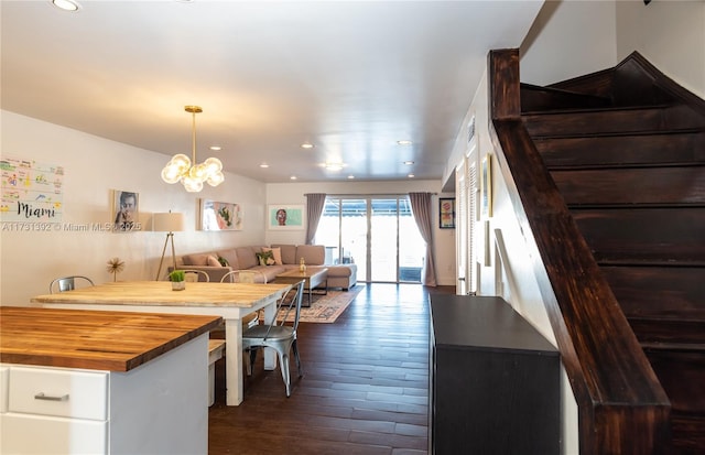 kitchen with dark hardwood / wood-style flooring, white cabinetry, hanging light fixtures, a notable chandelier, and wood counters