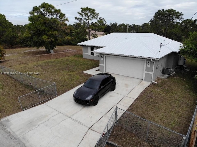 view of property exterior featuring a garage, a lawn, and central air condition unit