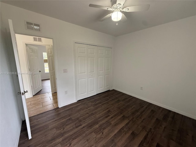 unfurnished bedroom featuring dark hardwood / wood-style floors, ceiling fan, and a closet