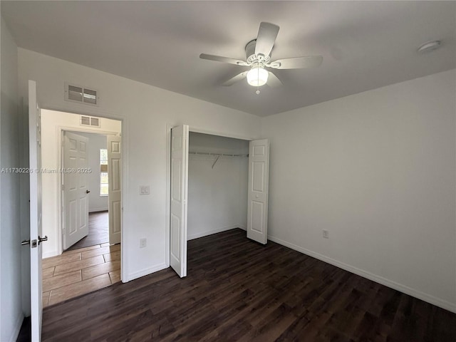 unfurnished bedroom with dark hardwood / wood-style flooring, a closet, and ceiling fan