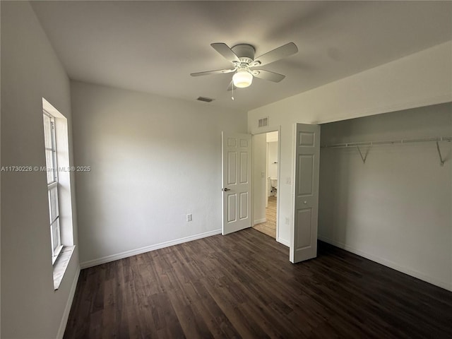 unfurnished bedroom featuring dark wood-type flooring, a closet, and ceiling fan