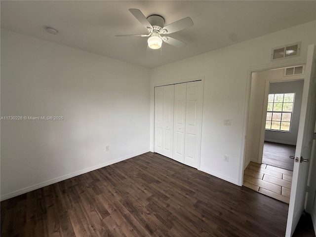 unfurnished bedroom featuring dark hardwood / wood-style floors, a closet, and ceiling fan