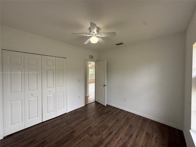 unfurnished bedroom with dark hardwood / wood-style flooring, ceiling fan, and a closet