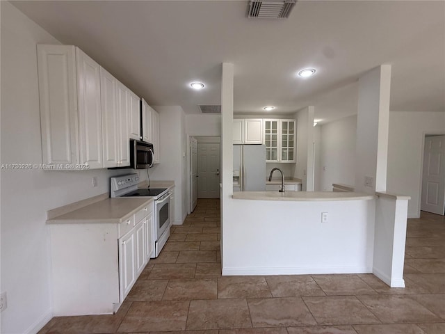 kitchen featuring stainless steel appliances, sink, white cabinets, and kitchen peninsula