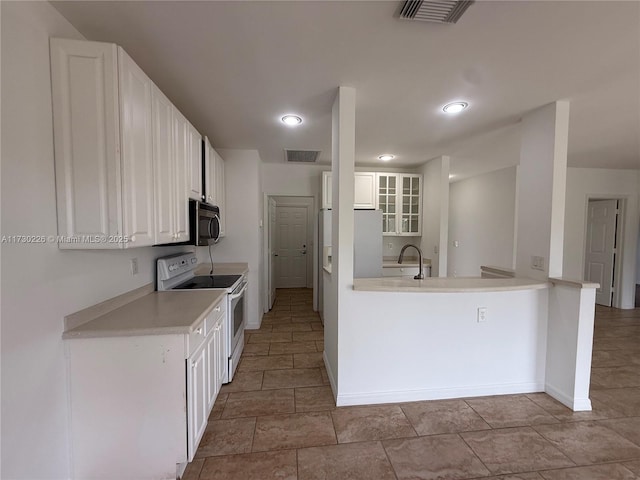 kitchen featuring electric stove, sink, white cabinetry, and kitchen peninsula