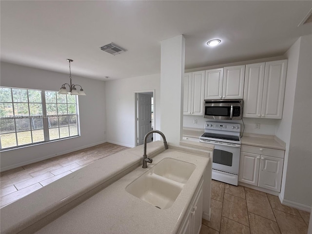 kitchen featuring white electric range, sink, white cabinetry, a chandelier, and pendant lighting