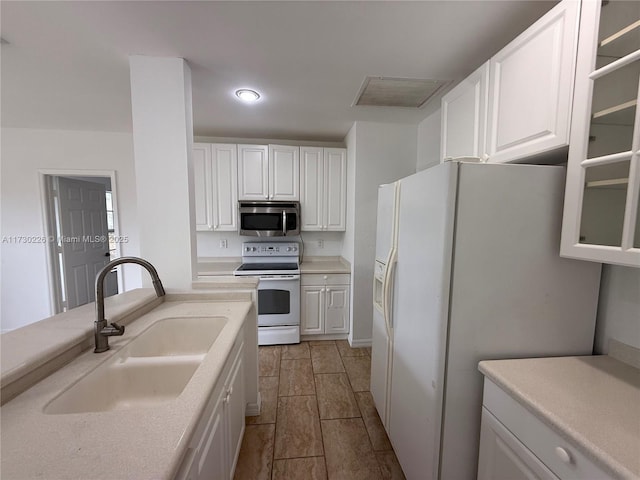 kitchen featuring sink, white appliances, and white cabinets