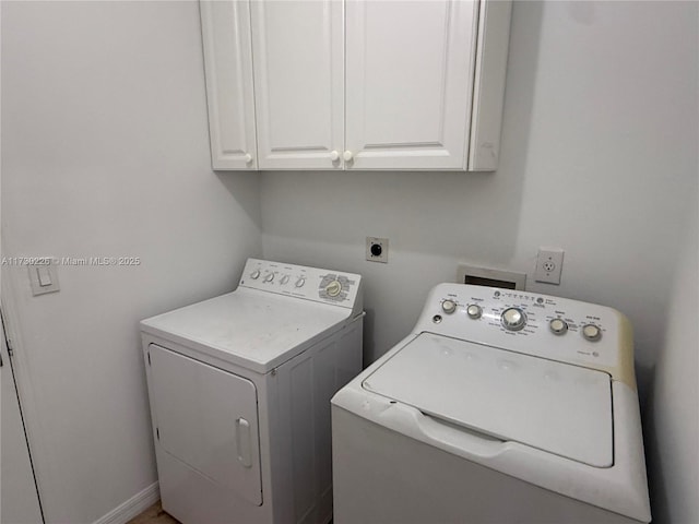 washroom with cabinets and washing machine and clothes dryer