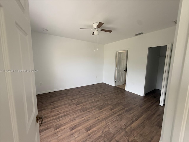 spare room with dark hardwood / wood-style floors and ceiling fan