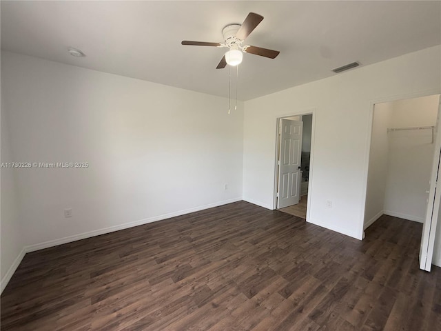 empty room featuring dark wood-type flooring and ceiling fan