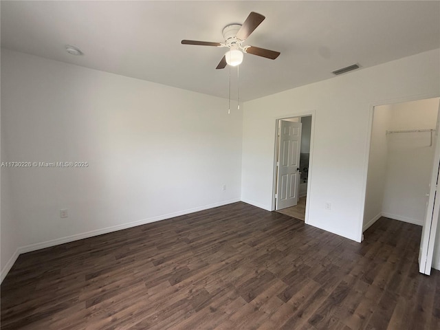 empty room with ceiling fan and dark hardwood / wood-style flooring