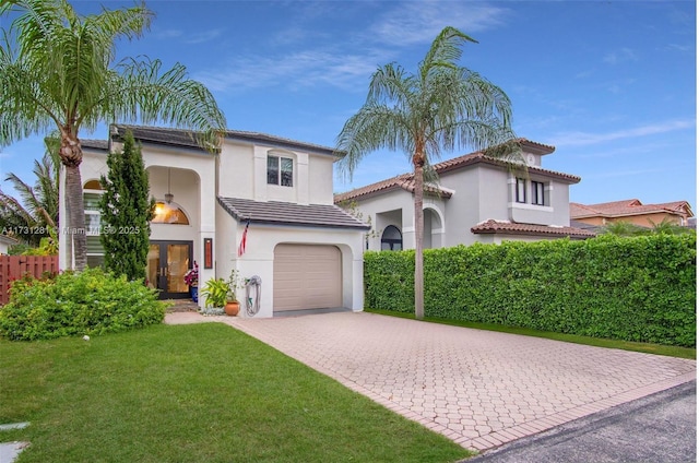 mediterranean / spanish house featuring a garage and a front yard