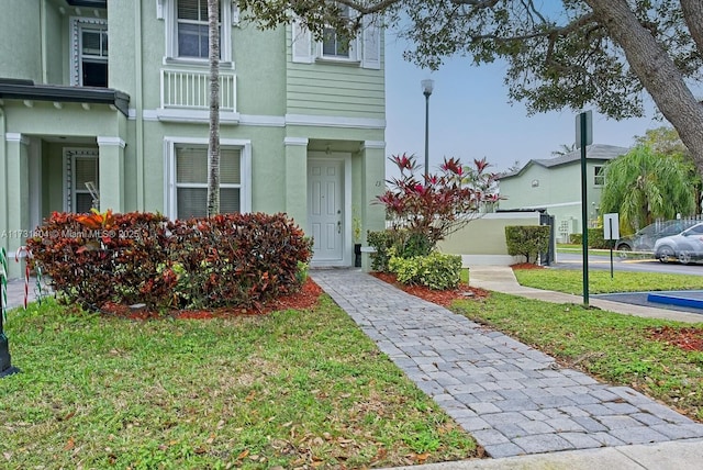 view of exterior entry featuring a lawn