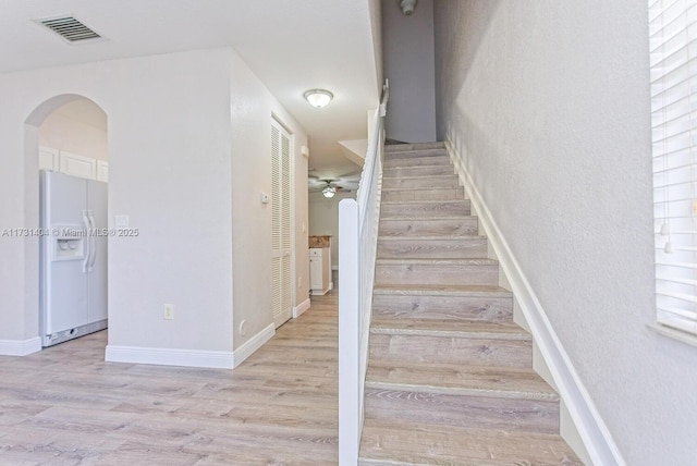 staircase with hardwood / wood-style flooring and ceiling fan