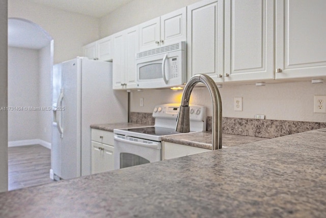 kitchen featuring white cabinets and white appliances