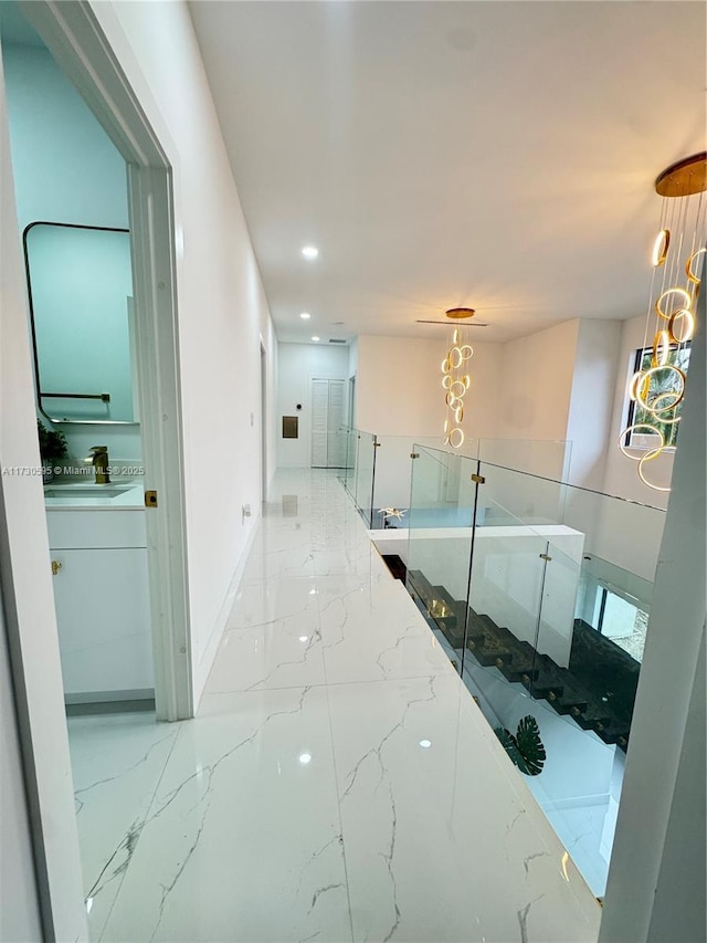 hall with sink and a chandelier