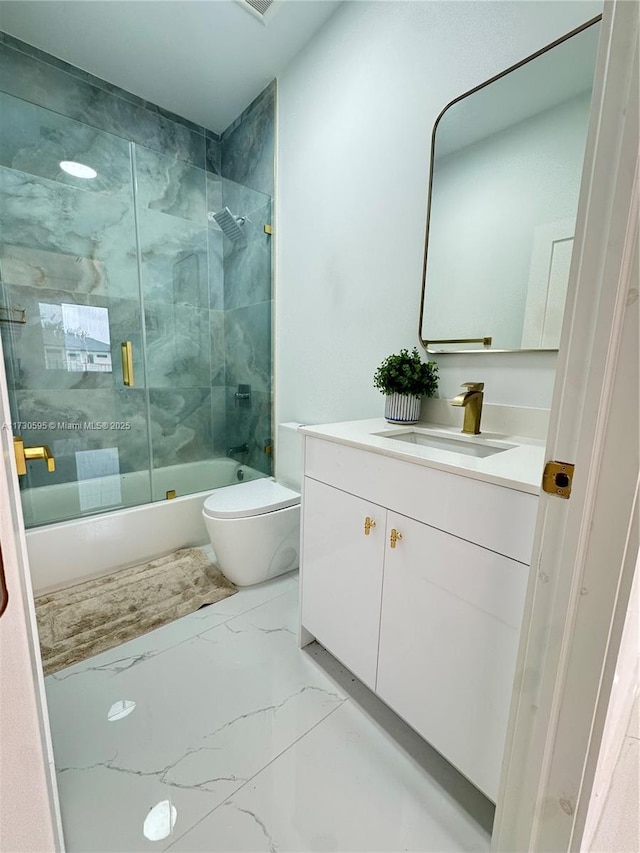 full bathroom with enclosed tub / shower combo, vanity, and toilet