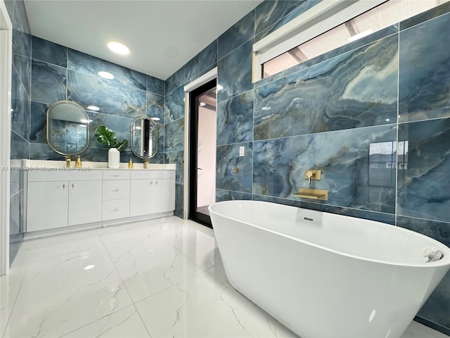 bathroom featuring vanity, tile walls, and a tub to relax in