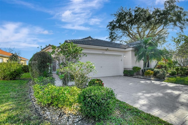 12915 Coral Lakes Dr, Boynton Beach, FL 33437 - view of side of property with a tiled roof, a garage, stucco siding, decorative driveway, and a yard