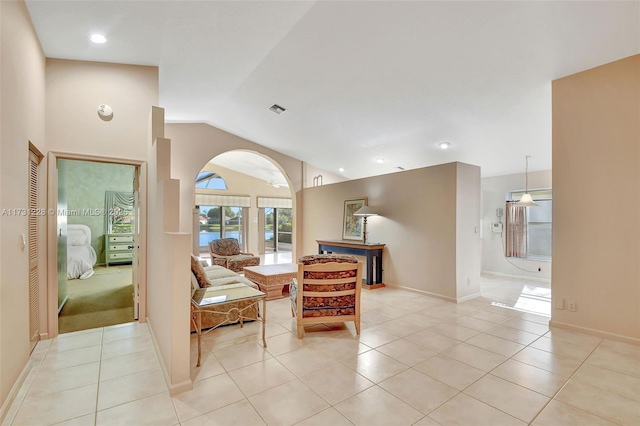 12915 Coral Lakes Dr, Boynton Beach, FL 33437 - living area with lofted ceiling, arched walkways, light tile patterned floors, and baseboards