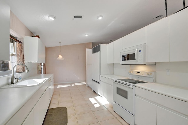 12915 Coral Lakes Dr, Boynton Beach, FL 33437 - kitchen featuring white appliances, a sink, light countertops, white cabinets, and hanging light fixtures
