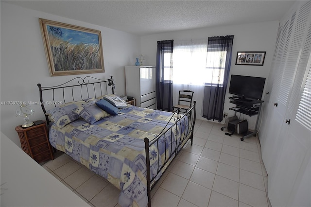 tiled bedroom featuring a closet and a textured ceiling