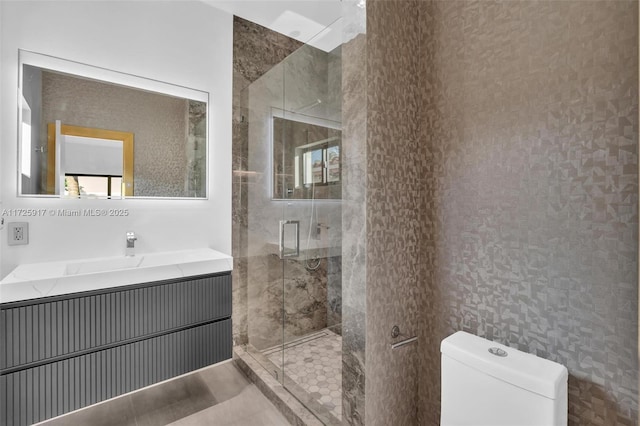 bathroom featuring a stall shower, vanity, and toilet