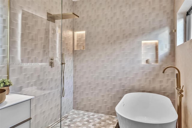 bathroom featuring a soaking tub, tiled shower, tile walls, and vanity