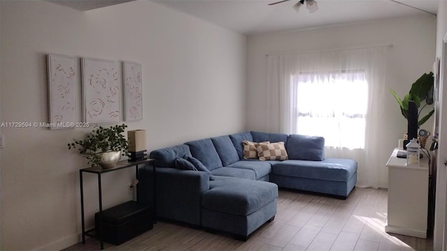 living room featuring ceiling fan and light hardwood / wood-style flooring