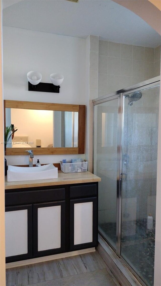 bathroom with vanity, hardwood / wood-style floors, and walk in shower