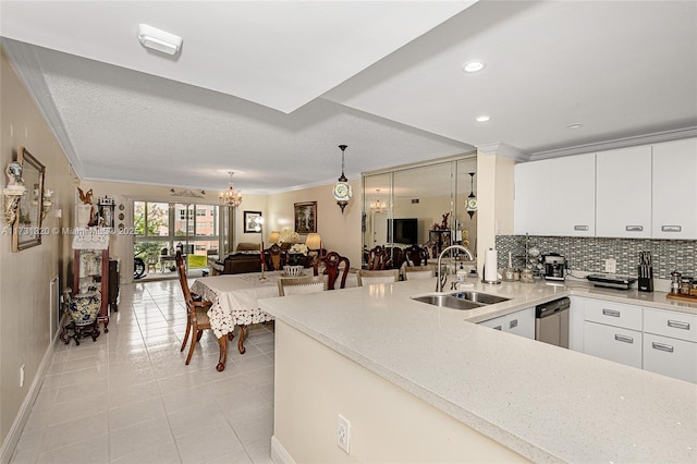 kitchen with pendant lighting, sink, white cabinetry, and dishwasher