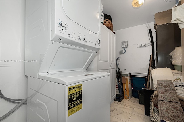 laundry area featuring cabinets and stacked washer and clothes dryer