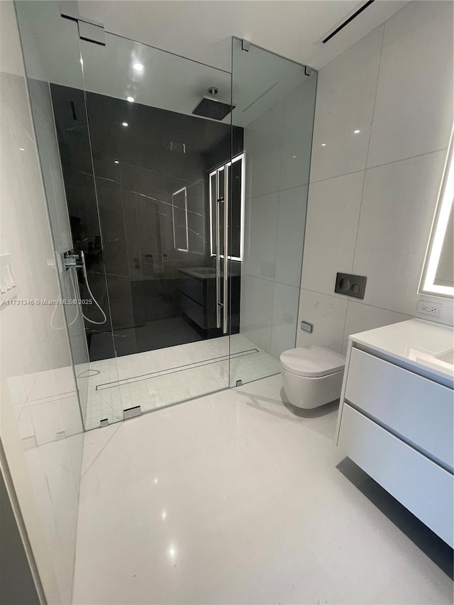 bathroom featuring vanity, tiled shower, tile walls, and toilet