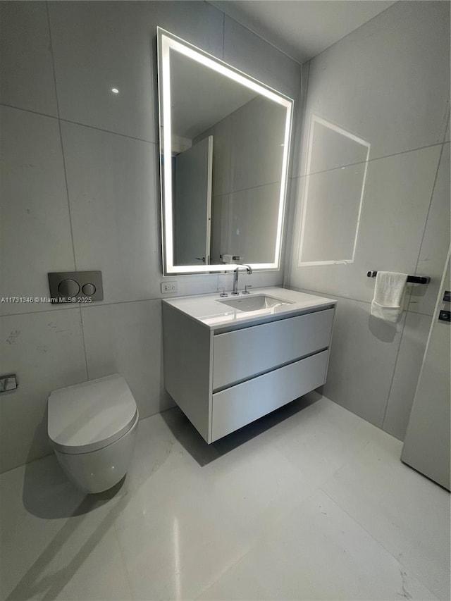 bathroom featuring tile walls, vanity, and toilet