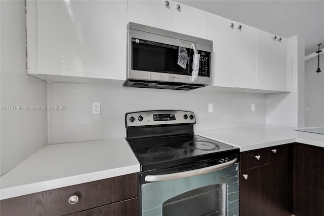 kitchen with white cabinetry, dark brown cabinetry, and appliances with stainless steel finishes