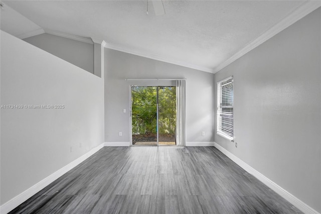 spare room with vaulted ceiling, ornamental molding, and dark wood-type flooring